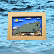 Load image into Gallery viewer, Framed glass artwork of a seal on a beach with ocean waves in the background